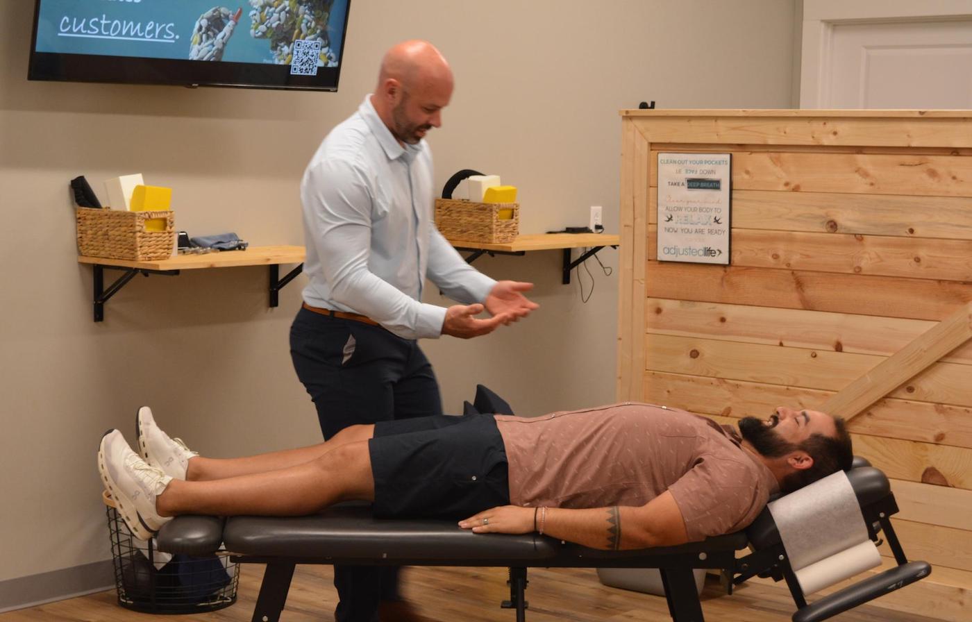 Dr. Coty Spraggs treating a man's automotive injury pain with chiropractic adjustment