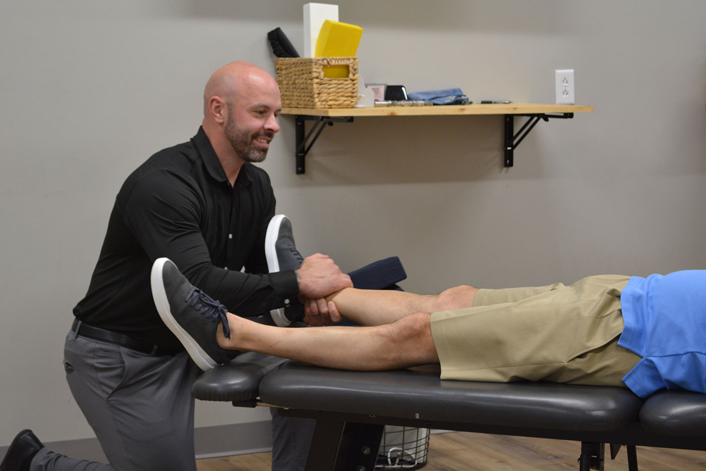 Dr. Coty Spraggs treating a young man's sports injury with a chiropractic adjustment
